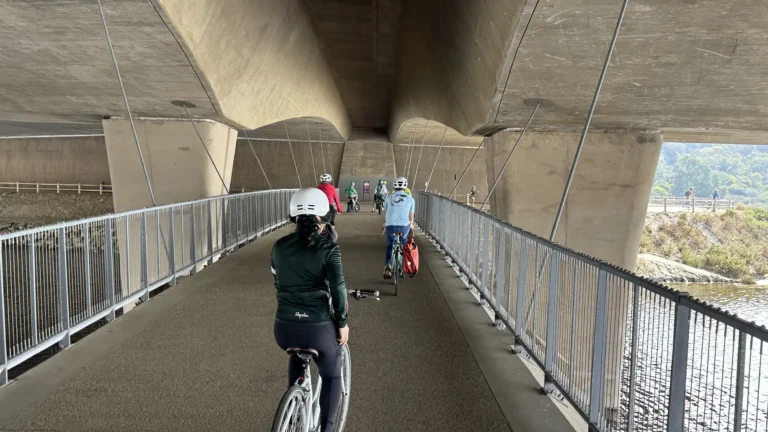 A group of cyclists ride on the bridge of the SANDAG North Coast Trail spanning the San Elijo Lagoon and also travels below Interstate 5 freeway between Encinitas and Solana Beach, California