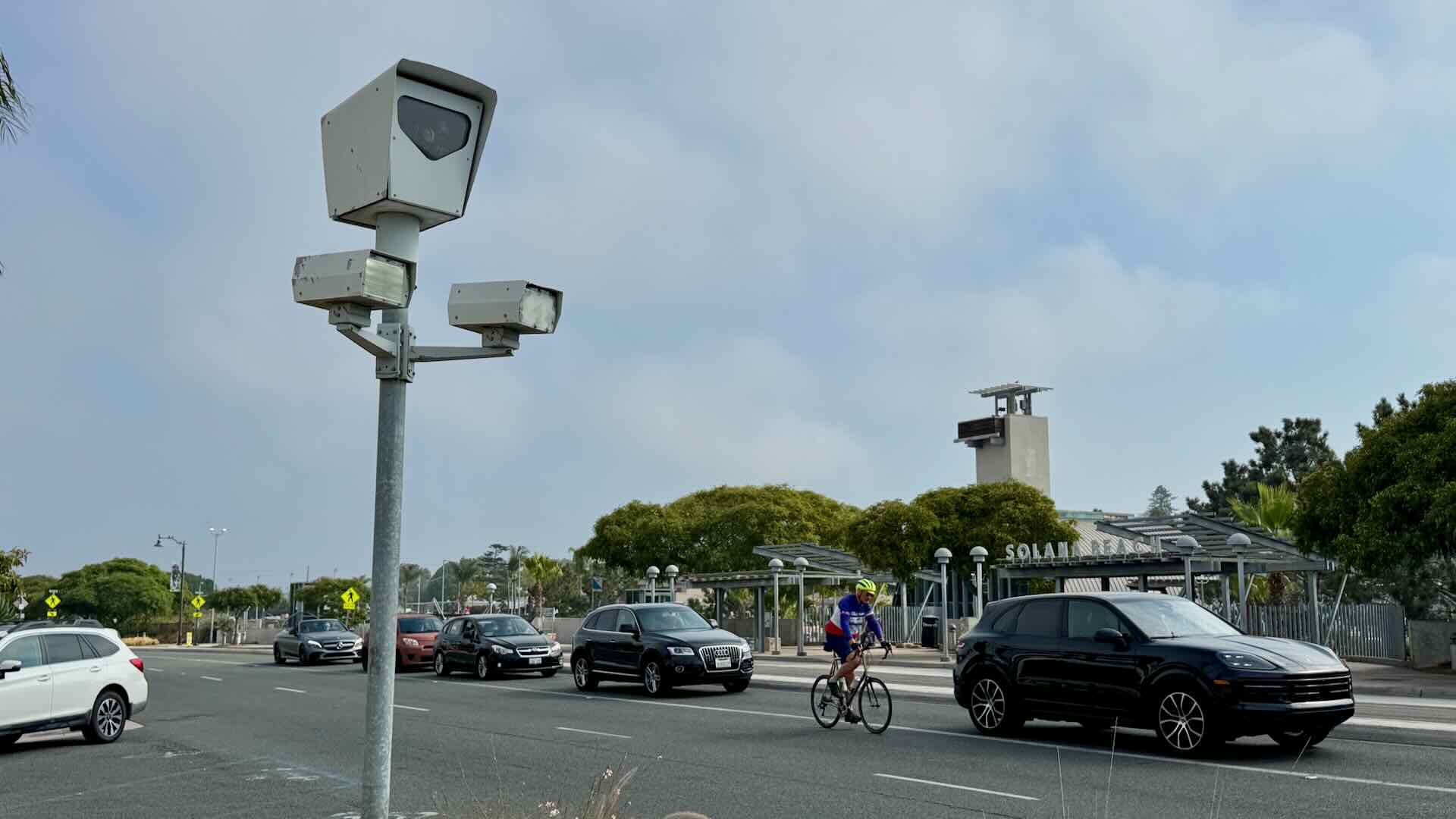 A red-light camera in Solana Beach, California with cars and a cyclist in the background